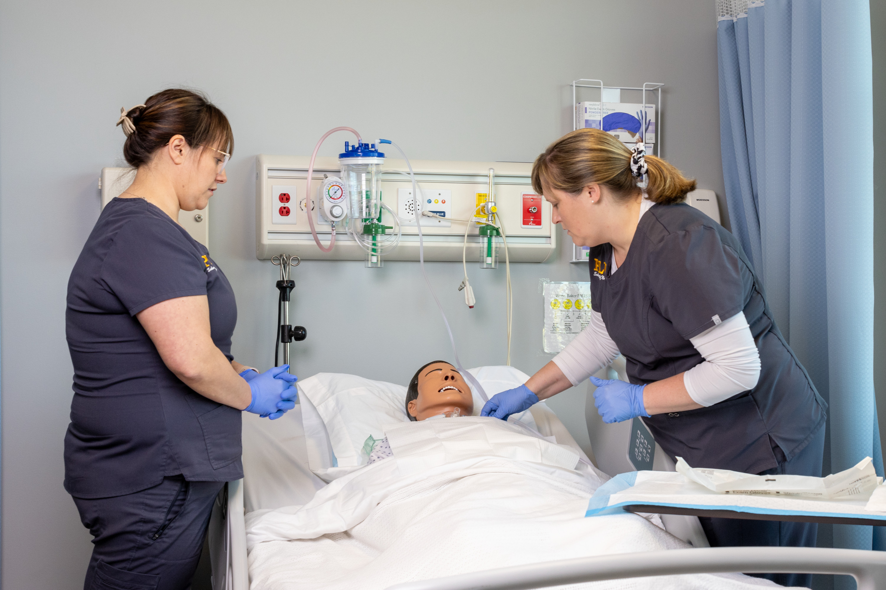 nursing students working with sim manikin