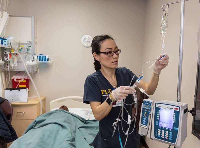 Pacific Lutheran University nursing student working with lab equipment