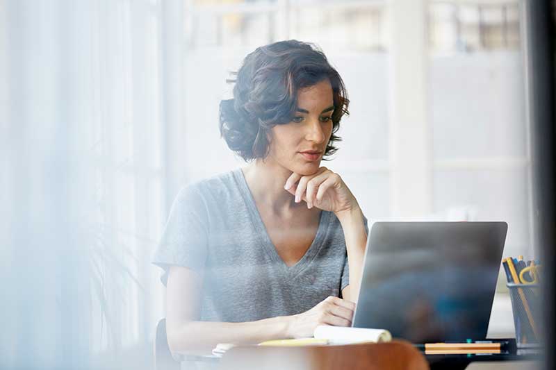 woman sitting at desk using laptop